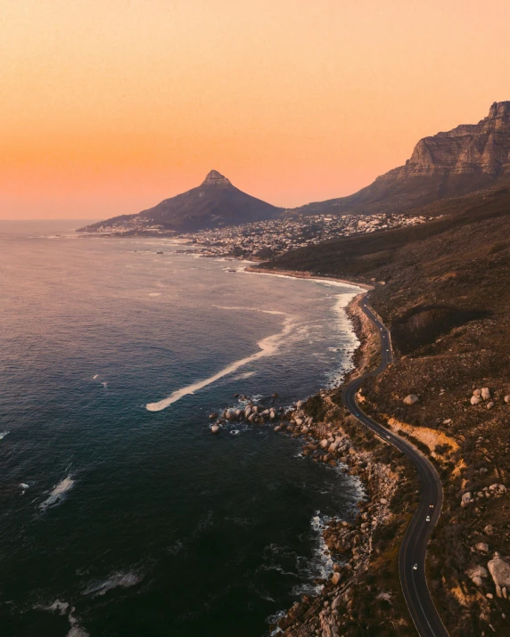 a large body of water with a mountain in the background, by Daniel Lieske, pexels contest winner, renaissance, south african coast, soft lighting from above, orange skies, a quaint