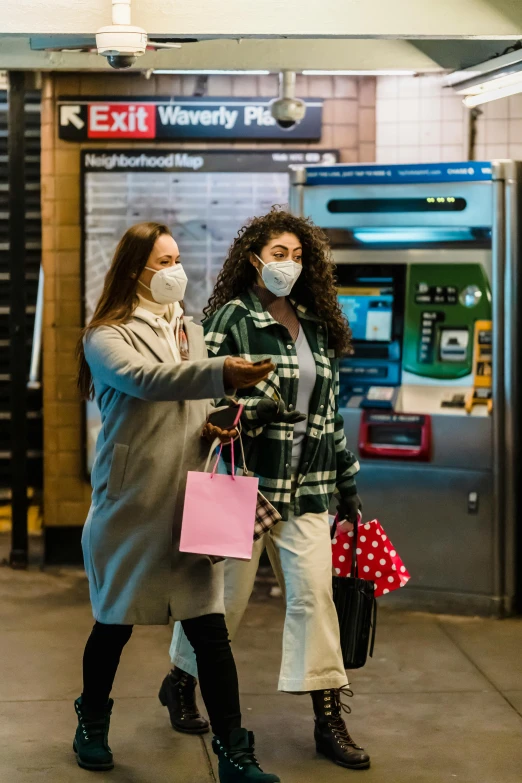 a couple of women standing next to each other on a subway platform, shutterstock, happening, wearing a mask, exiting store, square, f / 2 0