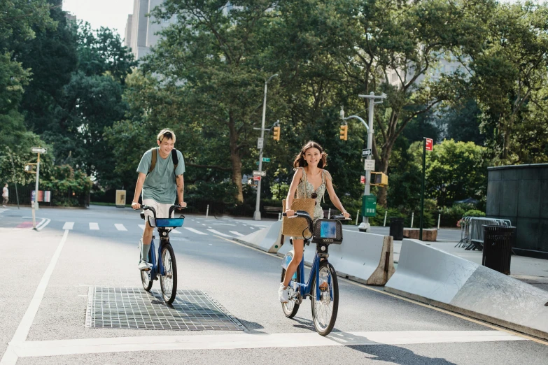 a couple of people riding bikes down a street, in new york, profile image, sydney sweeney, parks and public space