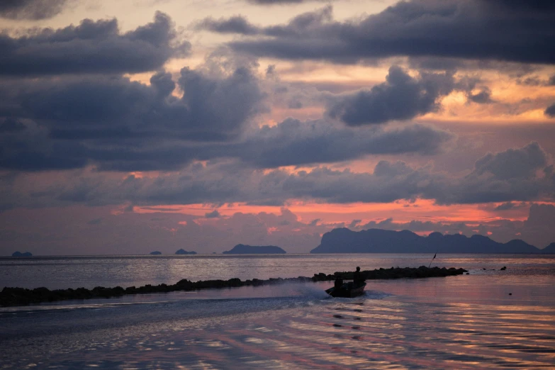 a boat on a body of water under a cloudy sky, inspired by Steve McCurry, pexels contest winner, romanticism, pink sunset hue, islands on horizon, thailand, subtitles