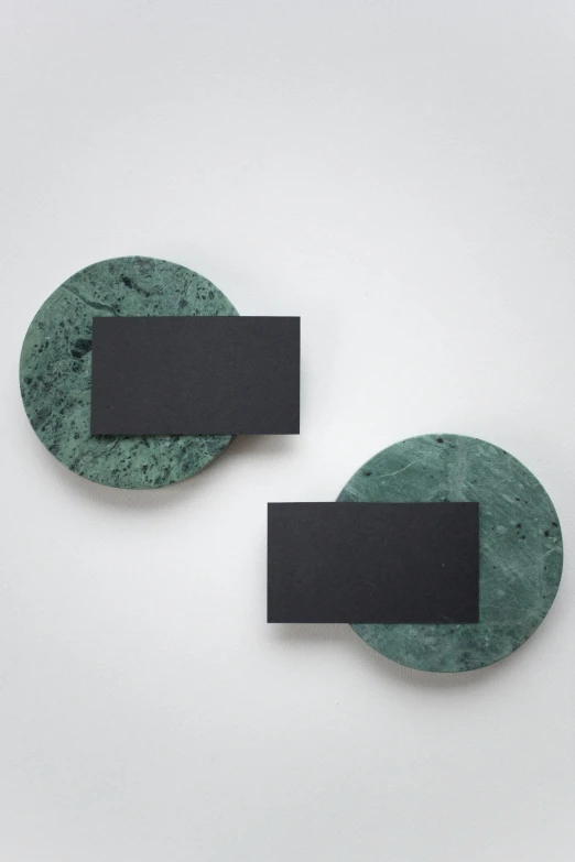 two pieces of green marble sitting on top of each other, by Harvey Quaytman, conceptual art, black circle, wall, magnetic, david kassan