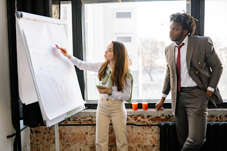 a man and a woman standing in front of a white board, pexels contest winner, people at work, sat in an office, building plans, charli bowater and artgeem