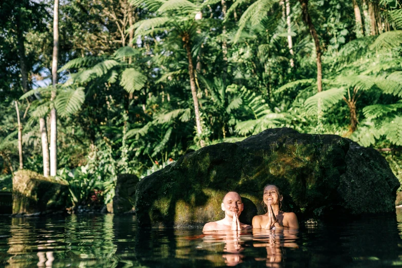 a couple of people that are in some water, unsplash, sumatraism, above lush garden and hot spring, avatar image, lachlan bailey, lush botany