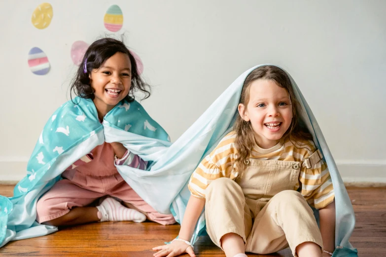 two little girls sitting on the floor under blankets, pexels contest winner, happening, easter, all overly excited, with teal clothes, thumbnail