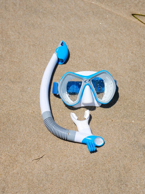 a diving mask and snorg lying on the sand, by Julian Allen, white and blue color scheme, full lenght view. white plastic, kids, detailed product image