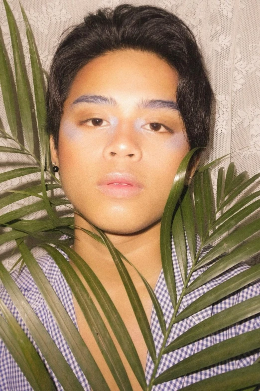 a close up of a person holding a plant, an album cover, androgynous face, hispanic, pastel makeup, tropical