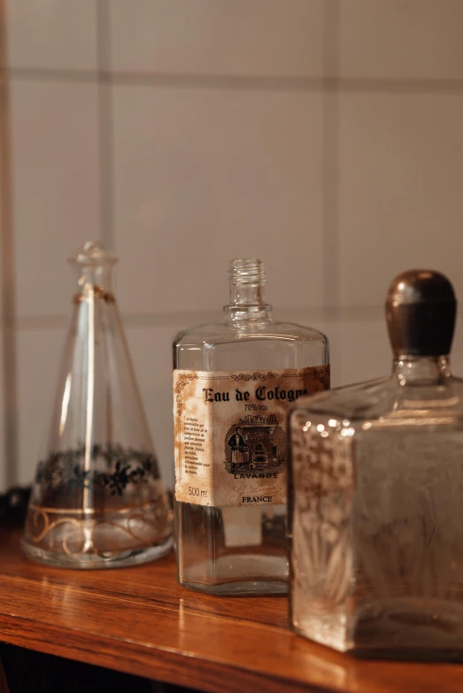 a couple of bottles sitting on top of a wooden table, a still life, unsplash, cabinet of curiosities, low quality photo, detailed product image, vintage footage