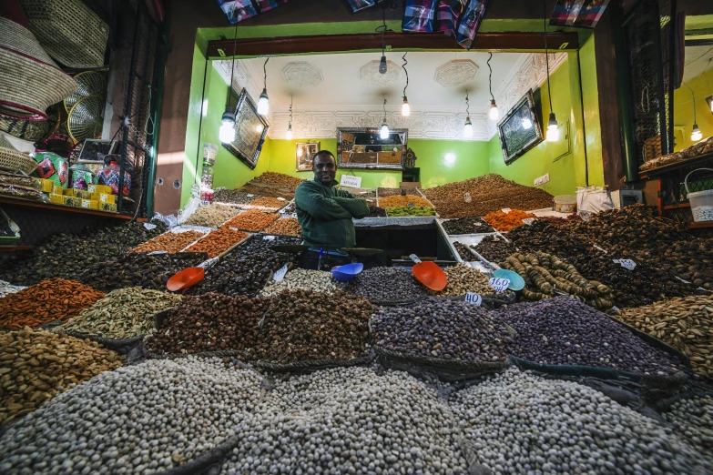 a man sitting in front of a pile of nuts, quirky shops, amr elshamy, getty images, thumbnail