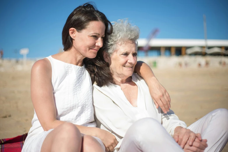 two women sitting next to each other on a beach, a portrait, by Niko Henrichon, pexels contest winner, dementia, woman holding another woman, 15081959 21121991 01012000 4k, white