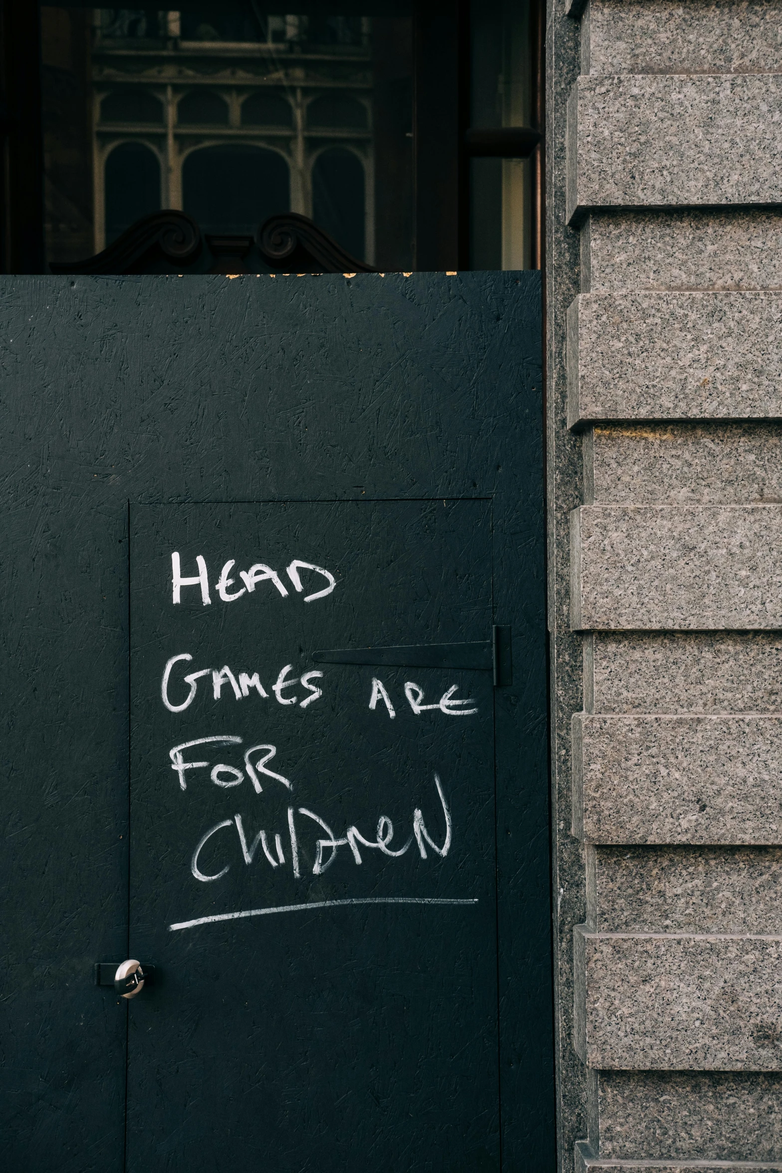 a black door with a sign that says head crimes are for children, a cartoon, by Jan Tengnagel, unsplash, playing games, hoog detail, up there, storefront