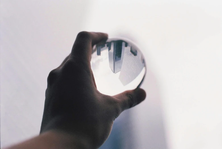 a person holding a crystal ball in their hand, by Julian Allen, unsplash contest winner, hyperrealism, photo of futuristic cityscape, black mirror, very high angle view, a round minimalist behind