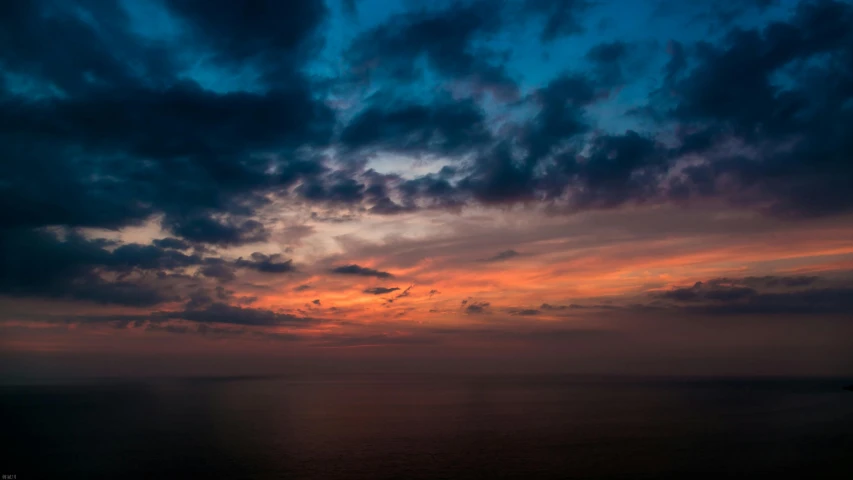 a large body of water under a cloudy sky, a picture, unsplash, romanticism, red sky blue, black sea, paul barson, orange and blue