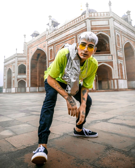 a man on a skateboard in front of a building, an album cover, trending on pexels, indian temple, an epic non - binary model, he is in a mosque, wearing sunglasses and a cap