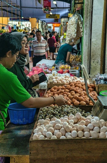 a group of people standing around a table filled with eggs, wet market street, manila, local foods, lush