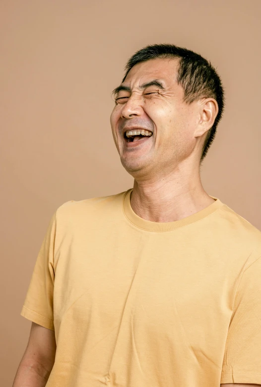 a man in a yellow shirt is laughing, inspired by Chen Daofu, pexels contest winner, plain background, mid - 3 0 s aged, light tan, alessio albi and shin jeongho