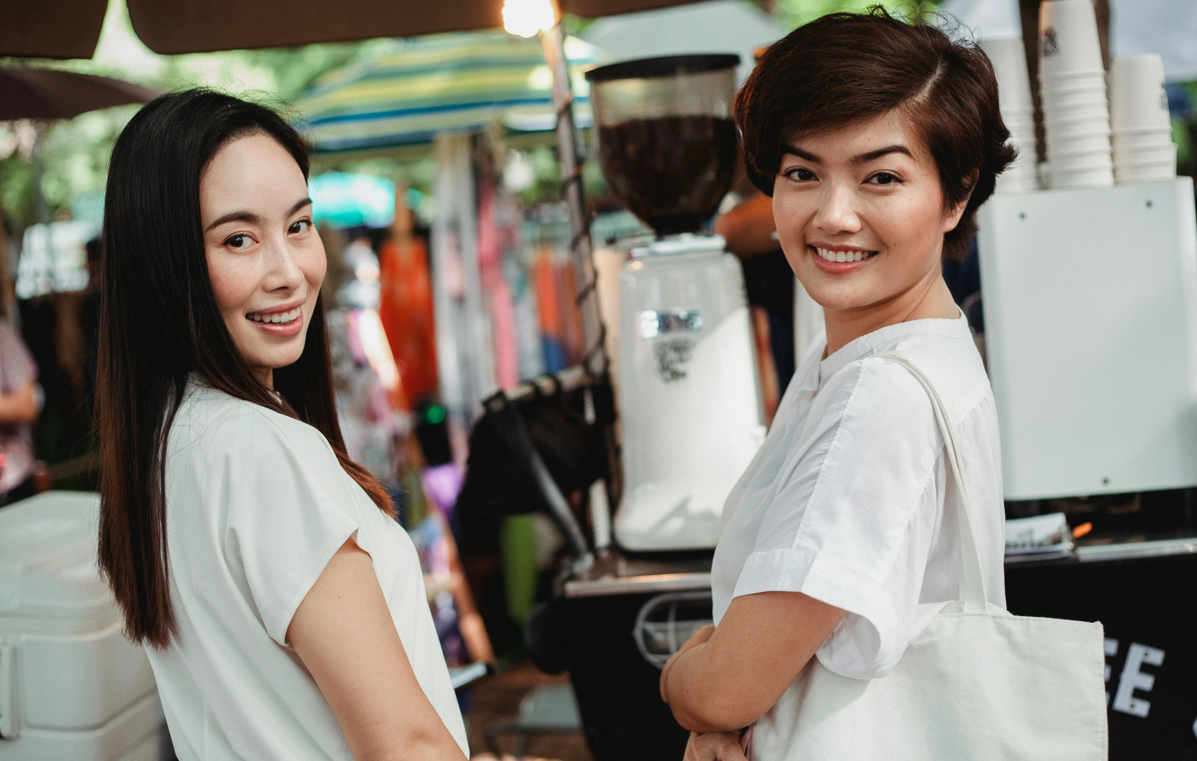 a couple of women standing next to each other, pexels contest winner, happening, bangkok townsquare, avatar image, markets, wearing a white shirt