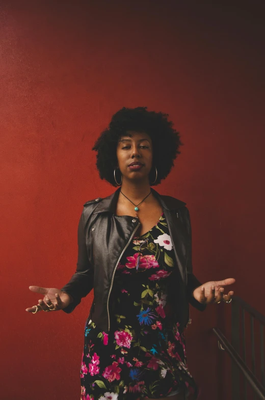 a woman standing in front of a red wall, black arts movement, keys, shrugging arms, slight overcast, square