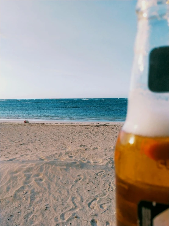 a bottle of beer sitting on top of a sandy beach, けもの, trending on vsco, inside a beer glass, ( ( ( ( kauai ) ) ) )