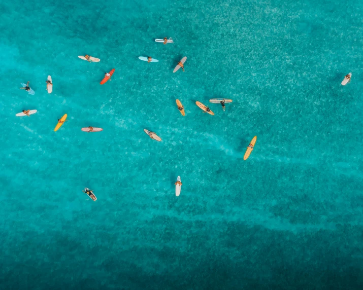 a group of people riding surfboards on top of a body of water, a tilt shift photo, by Adam Marczyński, pexels contest winner, minimalism, teal and orange, small canoes, ocean pattern, 1 2 9 7