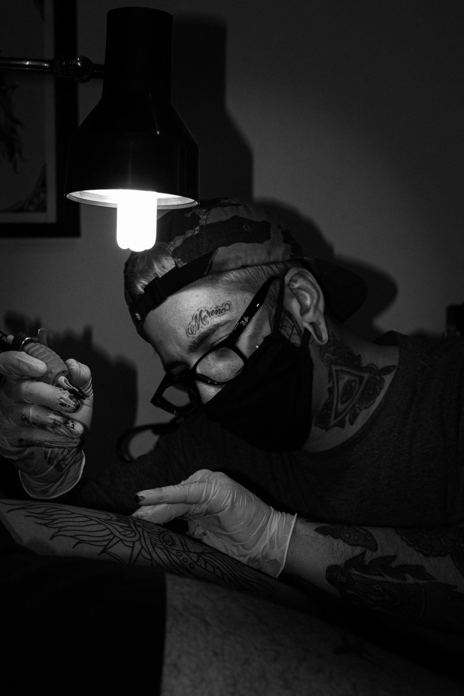 a black and white photo of a man getting a tattoo, reddit, hyperrealism, wearing facemask and sunglasses, (night), 2717433015, inked digital