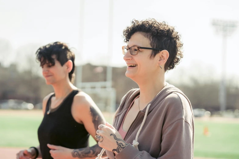 two women standing next to each other on a baseball field, pexels contest winner, renaissance, nonbinary model, sheryl sandberg at soulcycle, tattooed, rebecca sugar