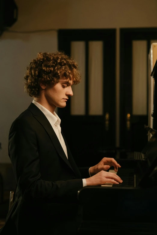 a man in a suit playing a piano, an album cover, unsplash, renaissance, he has short curly brown hair, thin young male, ignant, hasbulla magomedov