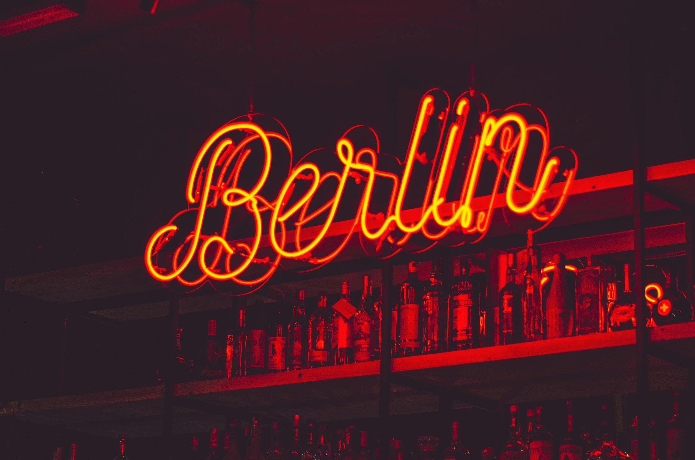 a bar with a neon sign that says berlin, pexels contest winner, berlin secession, red neon, medium closeup, 🦩🪐🐞👩🏻🦳, alcohol