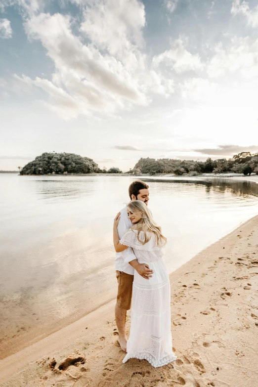 a man and woman standing next to each other on a beach, unsplash, maternal, lake setting, white, soft glow