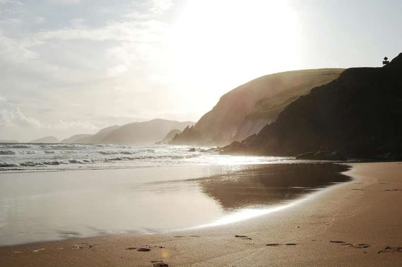 a person flying a kite on top of a sandy beach, profile image, coastal cliffs, sun down, clannad