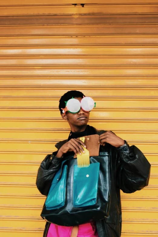 a man standing in front of a yellow garage door, an album cover, trending on pexels, afrofuturism, he wears an eyepatch, at a fashion shoot, bags under his eyes, 2019 trending photo