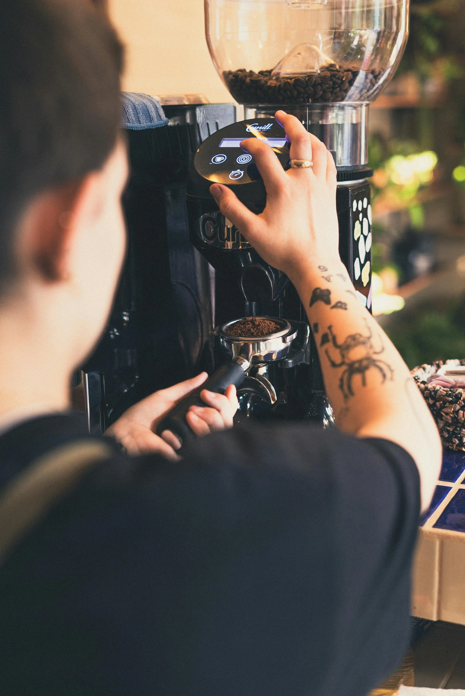 a man that is standing in front of a coffee machine, by Julia Pishtar, pexels contest winner, tattooed, organic detail, 15081959 21121991 01012000 4k, lush surroundings