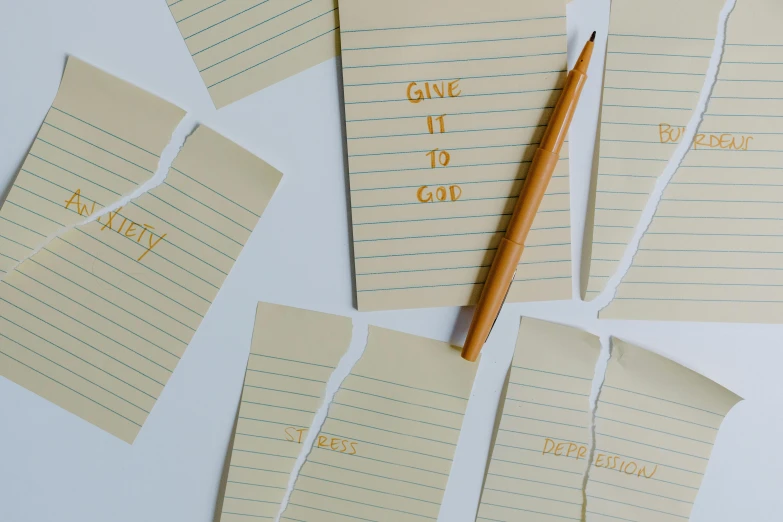 a number of pieces of paper with writing on them, by Carey Morris, trending on pexels, stressful, minimalistic composition, compassion, educational supplies