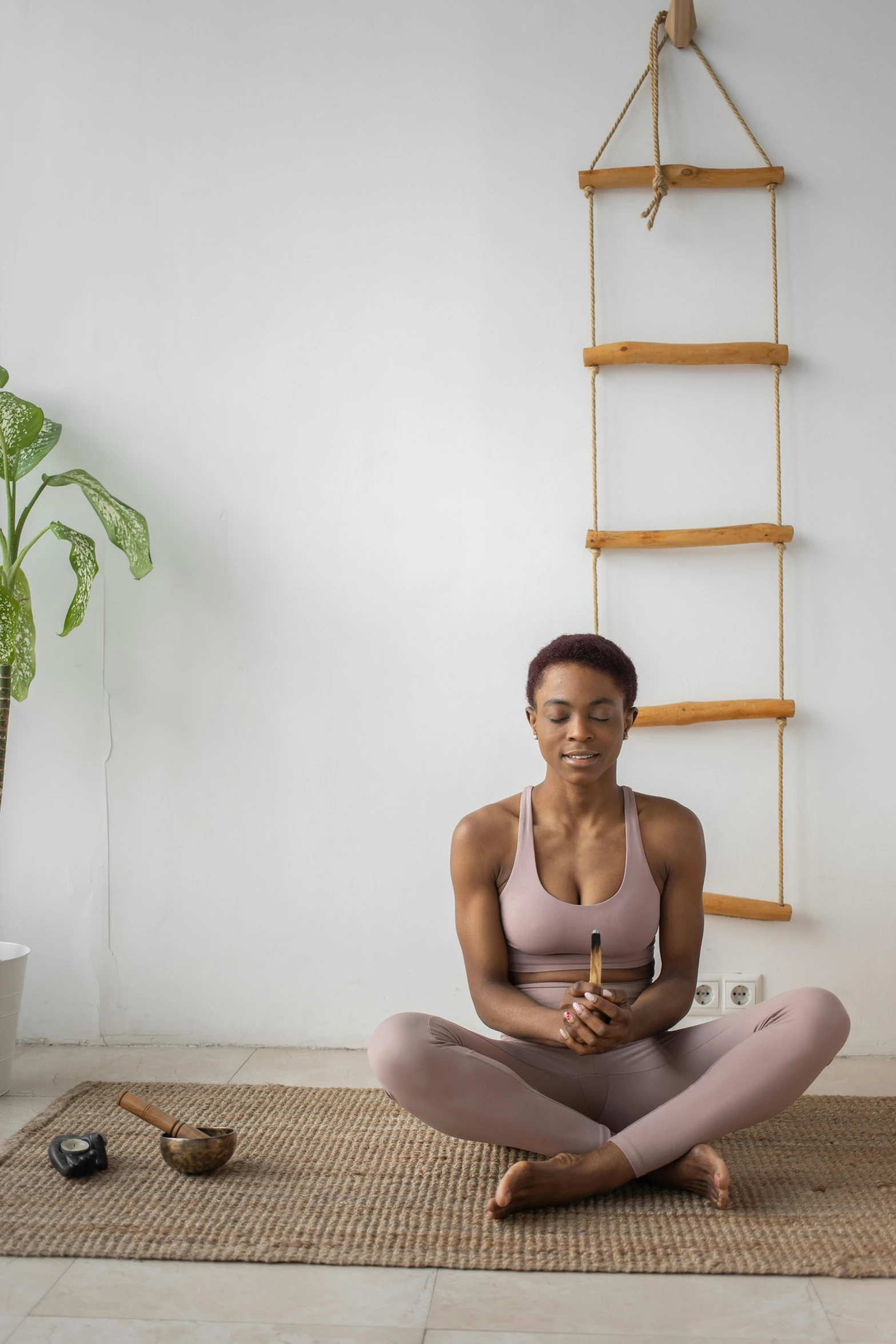a woman sitting on a yoga mat in front of a ladder, trending on pexels, renaissance, holding a wooden staff, contemplative, avatar image, profile image