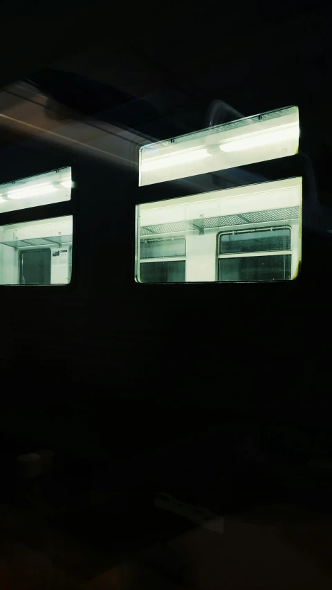 a train traveling down train tracks at night, a photocopy, inspired by Nan Goldin, postminimalism, inside of a tokyo garage, photo taken on fujifilm superia, the windows are lit, interior of a small