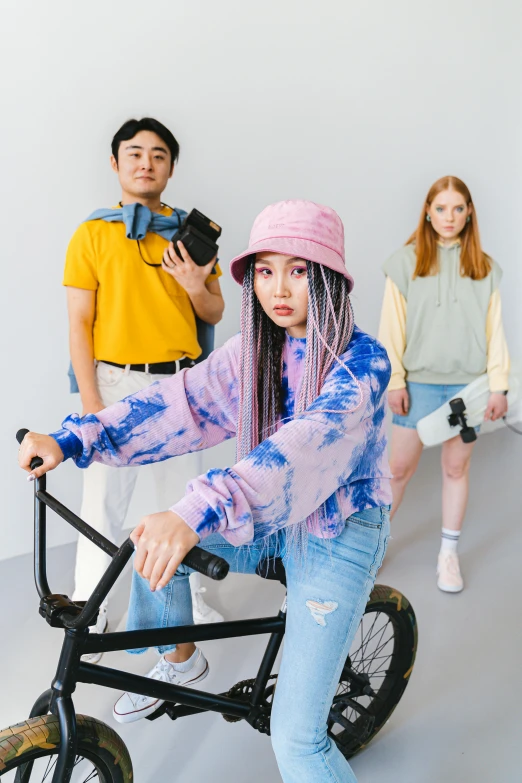 a group of people standing around a bike, she is wearing streetwear, pastel vibe, full product shot, asian descend