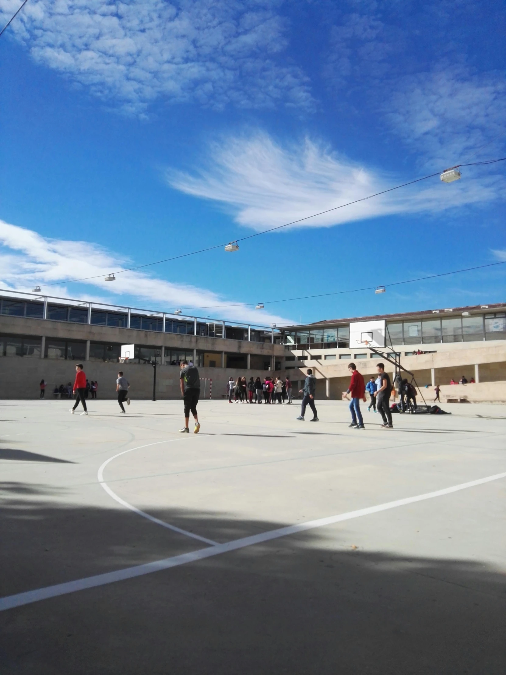 a group of people playing a game of basketball, quito school, background image, trending on vsco, blue sky, at college