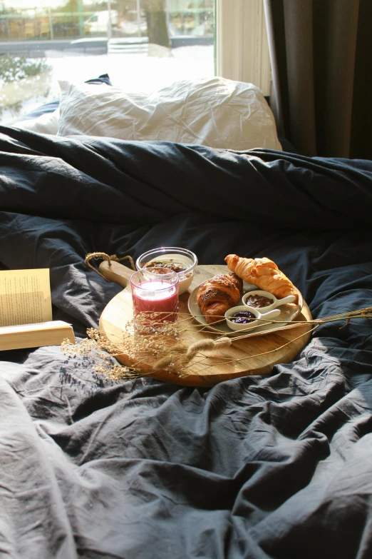 a tray of food sitting on top of a bed, by Jessie Algie, unsplash, romanticism, bread, manuka, french, on a wooden plate