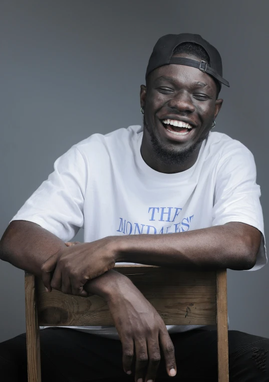 a man sitting on top of a wooden chair, by Stokely Webster, smiling maniacally, grime, bet face, thomas kinade