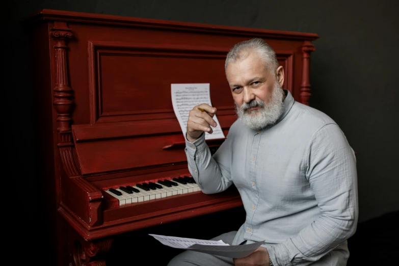 a man sitting in front of a red piano, grey beard, alina ivanchenko, high-quality photo, 15081959 21121991 01012000 4k