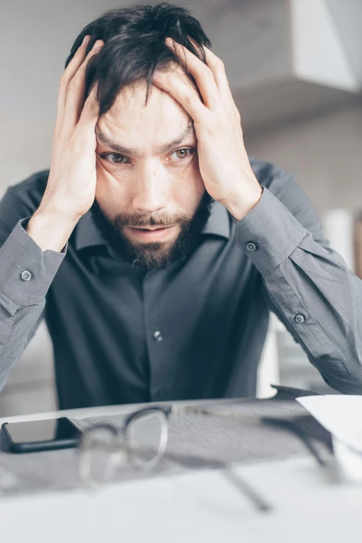 a man sitting at a table with his head in his hands, looking confused, sweaty and gross pioneer work, reddit post, stressed out