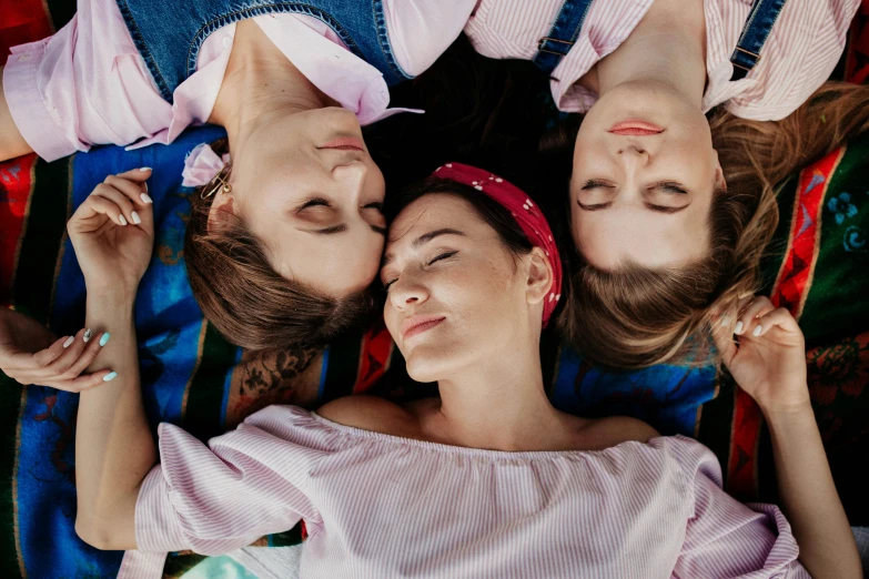 a group of women laying on top of each other, trending on pexels, three heads, wearing a headband, romantic period, top down shot