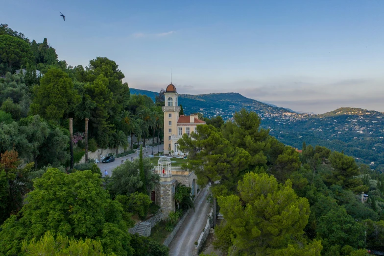 a large building sitting on top of a lush green hillside, les nabis, nice view, in the evening, conde nast traveler photo, taken in the early 2020s