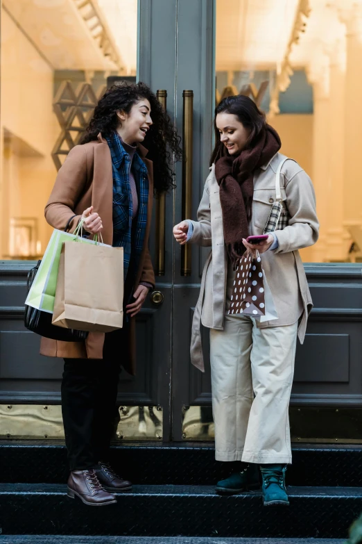 two women standing outside of a building with shopping bags, pexels contest winner, renaissance, talking, winter, promotional image, brown