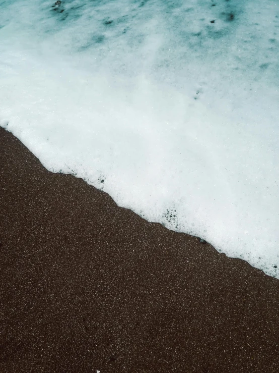 a person riding a surfboard on top of a sandy beach, pexels contest winner, minimalism, wave of water particles, chocolate, ignant, low quality photo