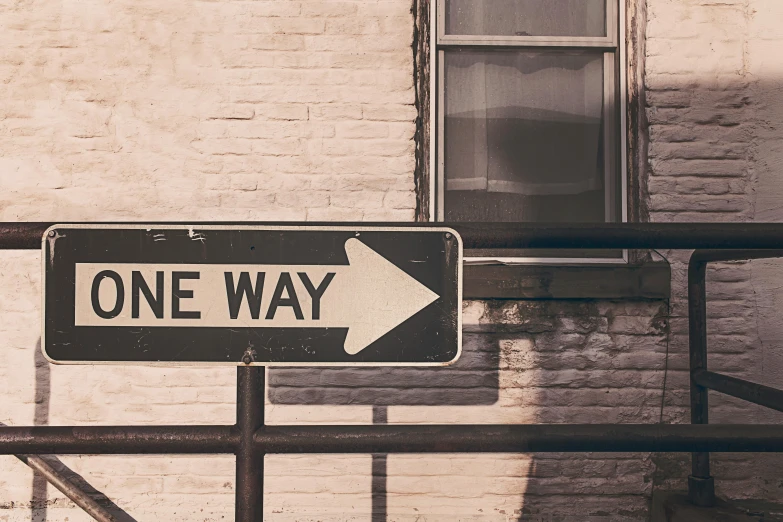 a one way sign in front of a brick building, trending on unsplash, vintage photo, 🚿🗝📝