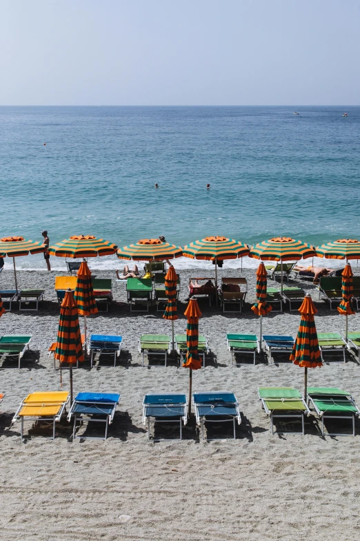 a bunch of beach chairs and umbrellas on a beach, by Carlo Martini, cinq terre, striped orange and teal, ocean view, square