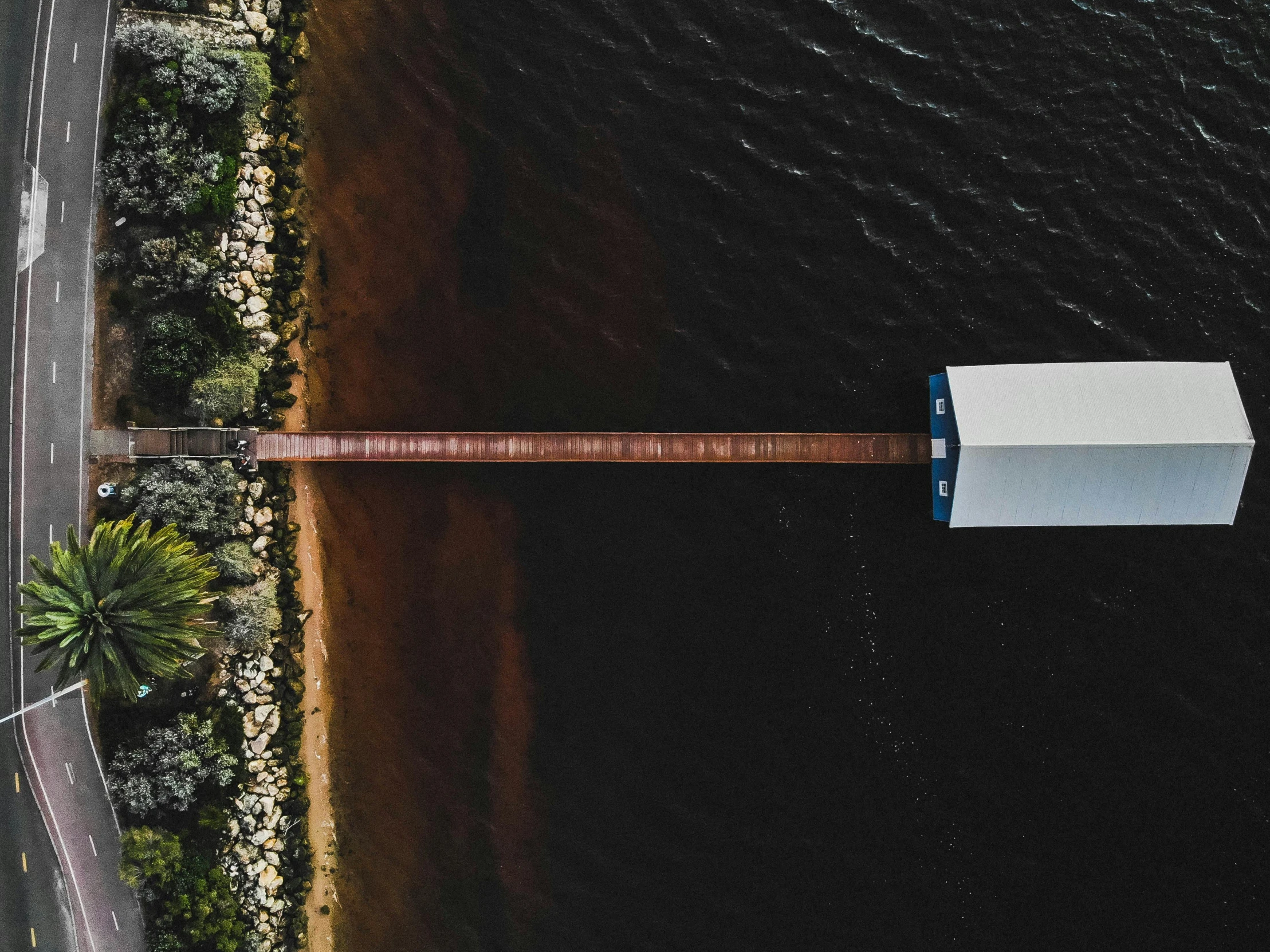 an aerial view of a street next to a body of water, by Daniel Lieske, pexels contest winner, hurufiyya, covered bridge, near a jetty, ultrawide image, half and half