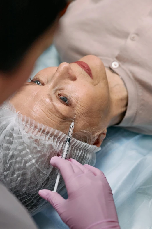 a close up of a person with a mask on, surgical impliments, square facial structure, older woman, creating a soft