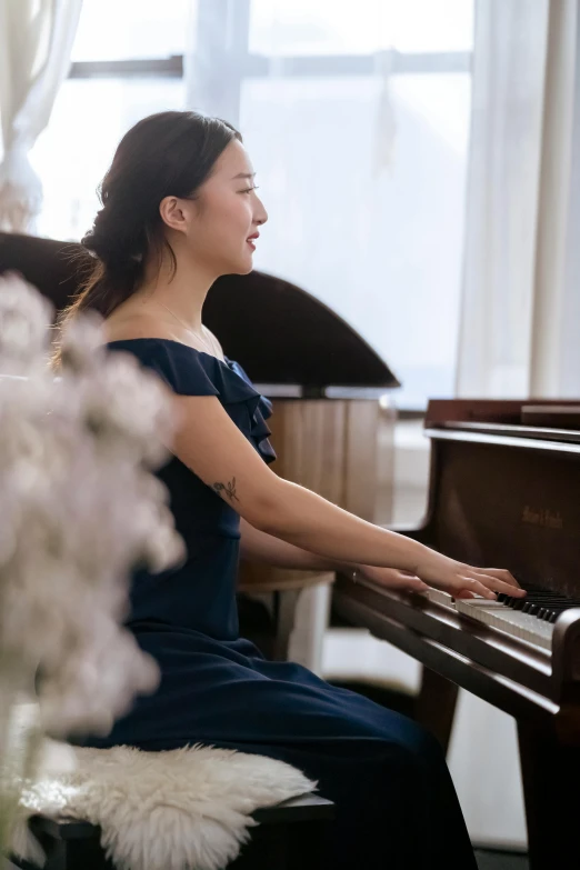 a woman in a blue dress sitting at a piano, katherine lam, blooming, in house, profile image