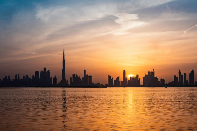 a large body of water with a city in the background, by Julia Pishtar, pexels contest winner, hurufiyya, dubai, golden hour sunset, youtube thumbnail, heat shimmering